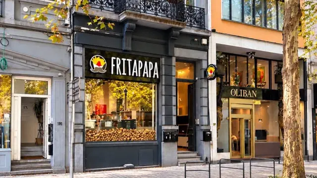 La devanture d’une friterie Fritapapa à Bruxelles : enseigne noire et blanche, vitrine garnie de pommes de terre.